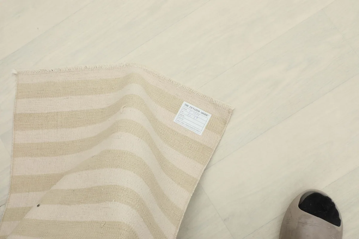 Top-down view of the rug with a foot for scale, showing the care label on the back.