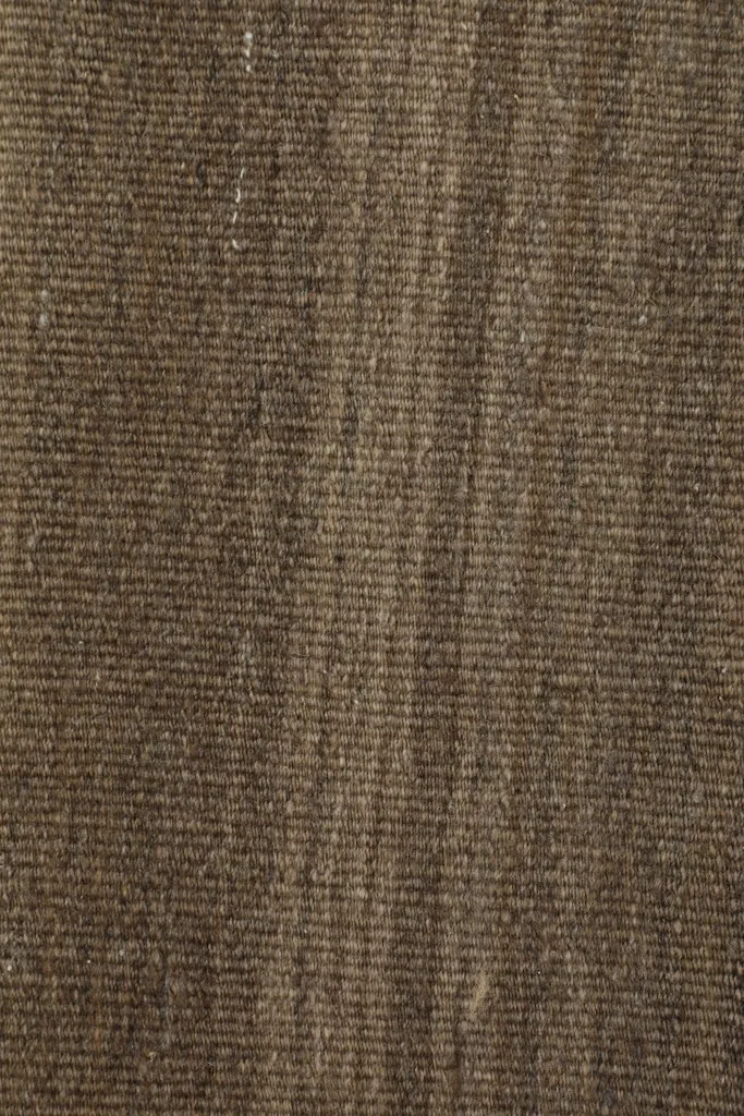 Texture close-up of the brown wool pile, emphasizing the natural fibers and hand-knotted construction.