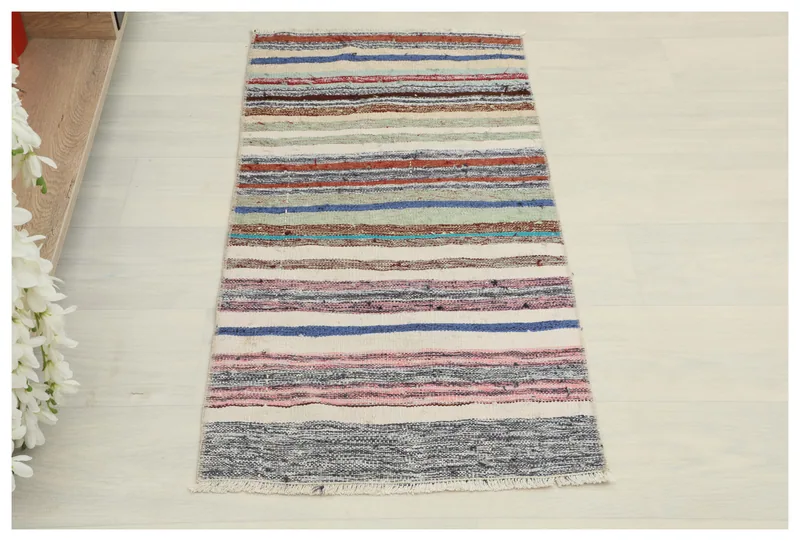 Full top view of the multicolor striped vintage Anatolian rug on a white background.