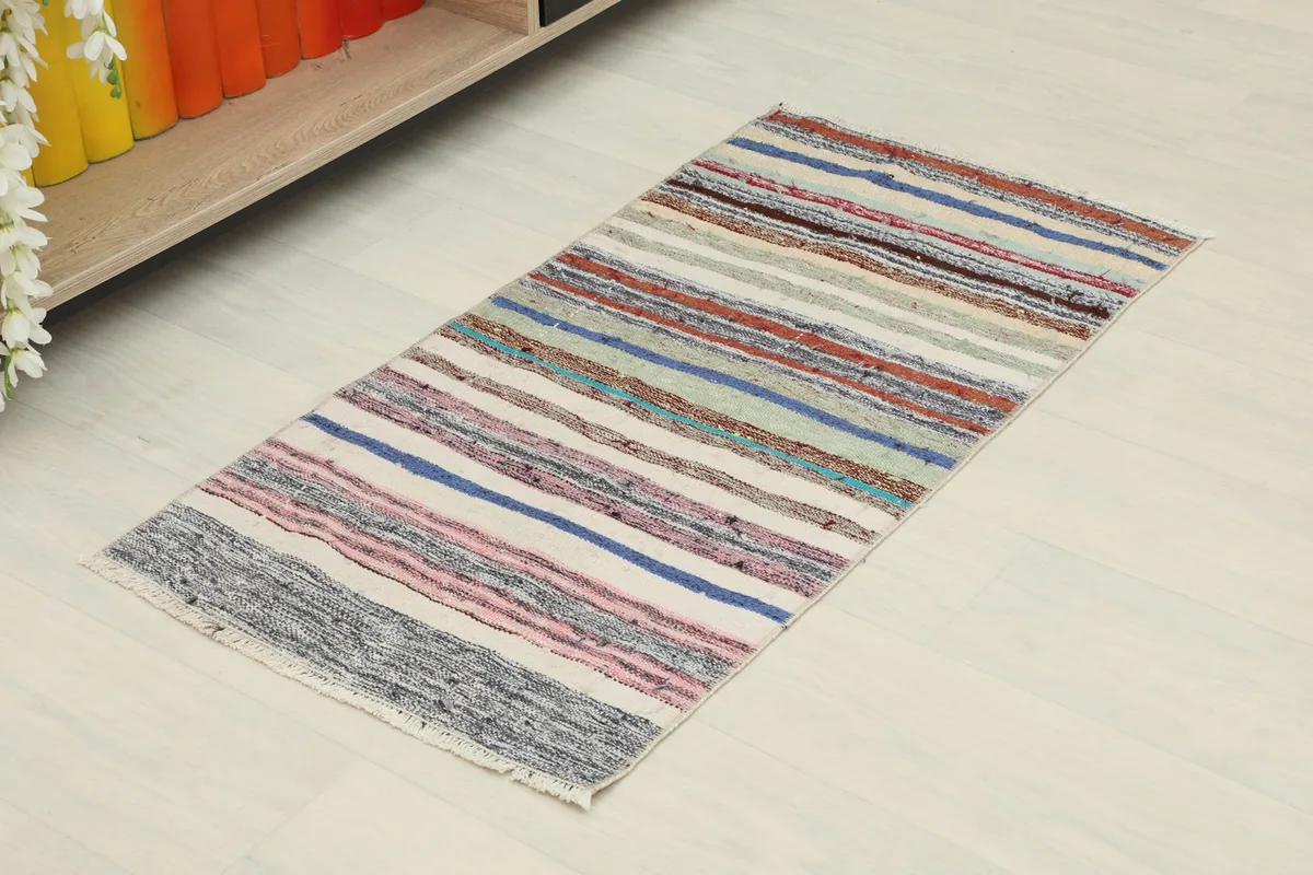 Overhead angled view of the striped vintage rug, showing its full length and colors.