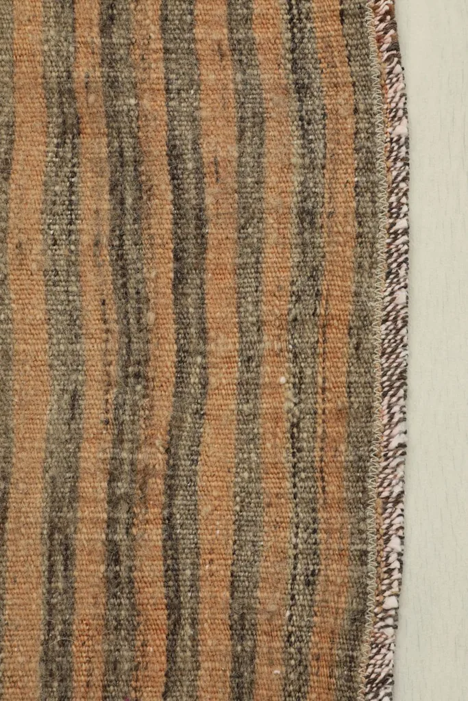 Close-up detail of the tan and charcoal striped pattern and wool pile texture.