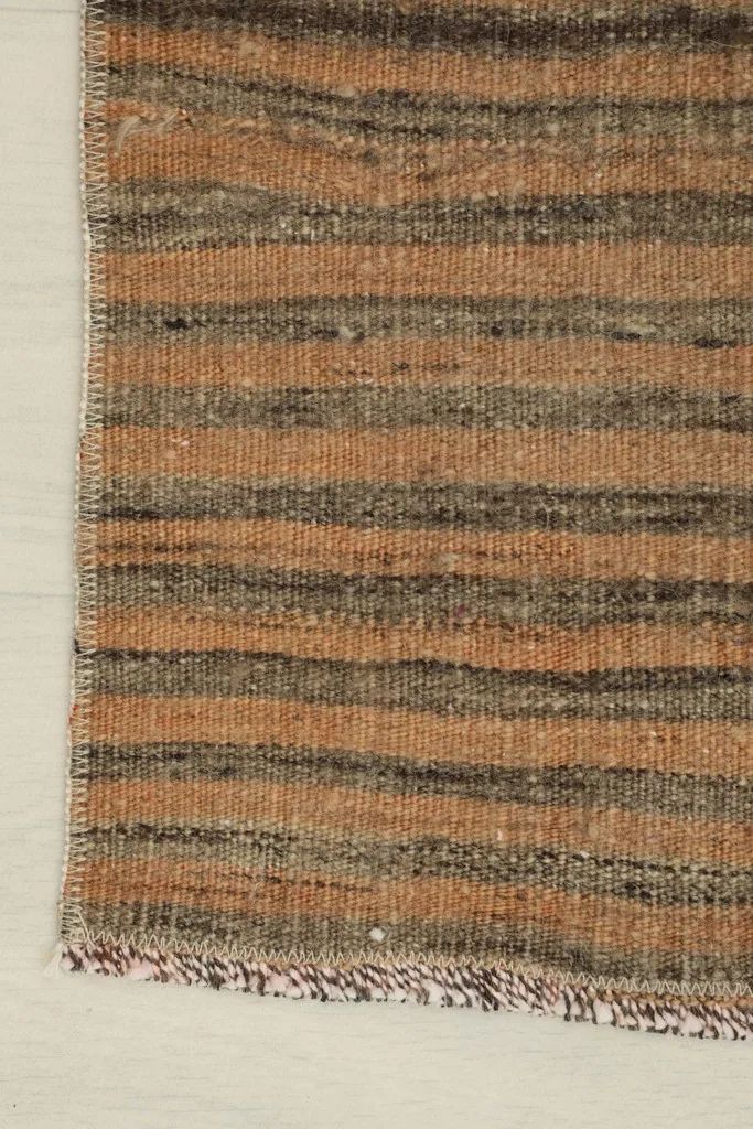 Detail of the rug's edge, showing the finished side and the striped pattern.
