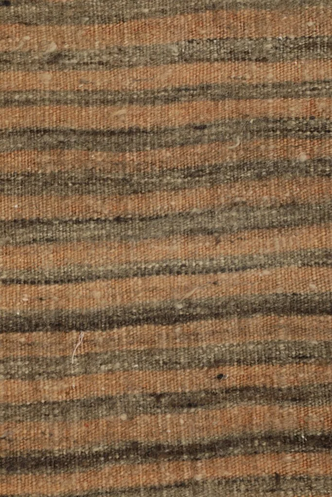 Tight close-up of the low wool pile and the distinct tan and charcoal stripes.