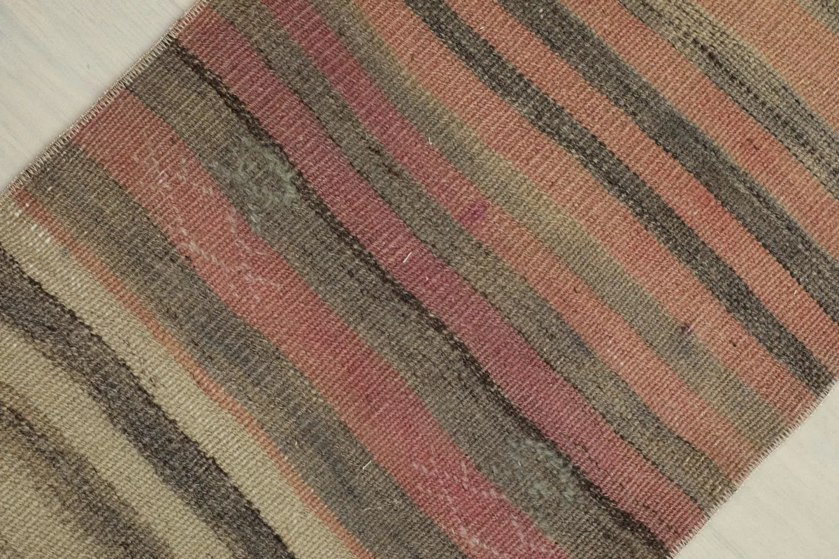 Angled close-up showing the texture and color variations within the rose, gray, and beige stripes.