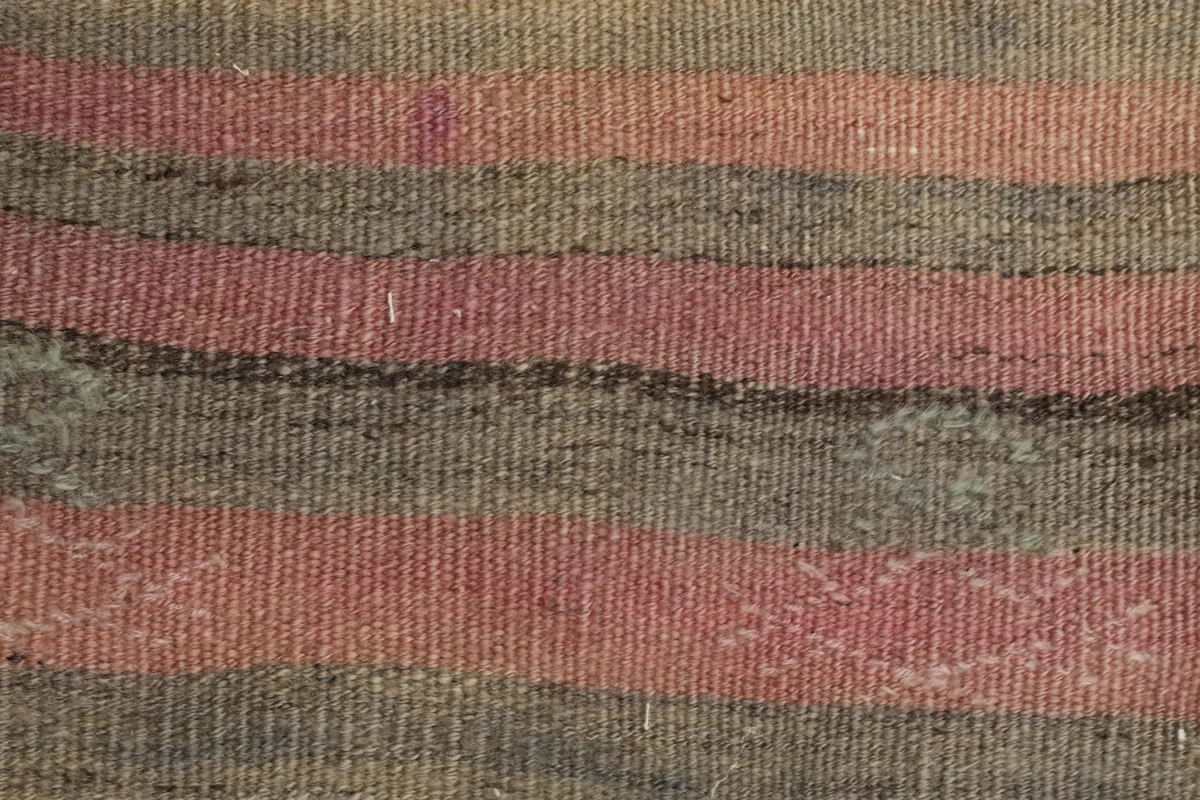 Tight close-up of the low wool pile, highlighting the hand-knotted texture and striped pattern details.