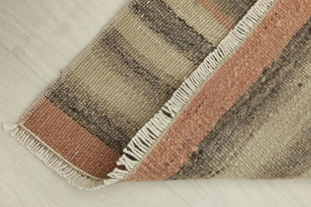 The doormat folded back to reveal the cotton foundation and the reverse side of the hand-knotted construction.