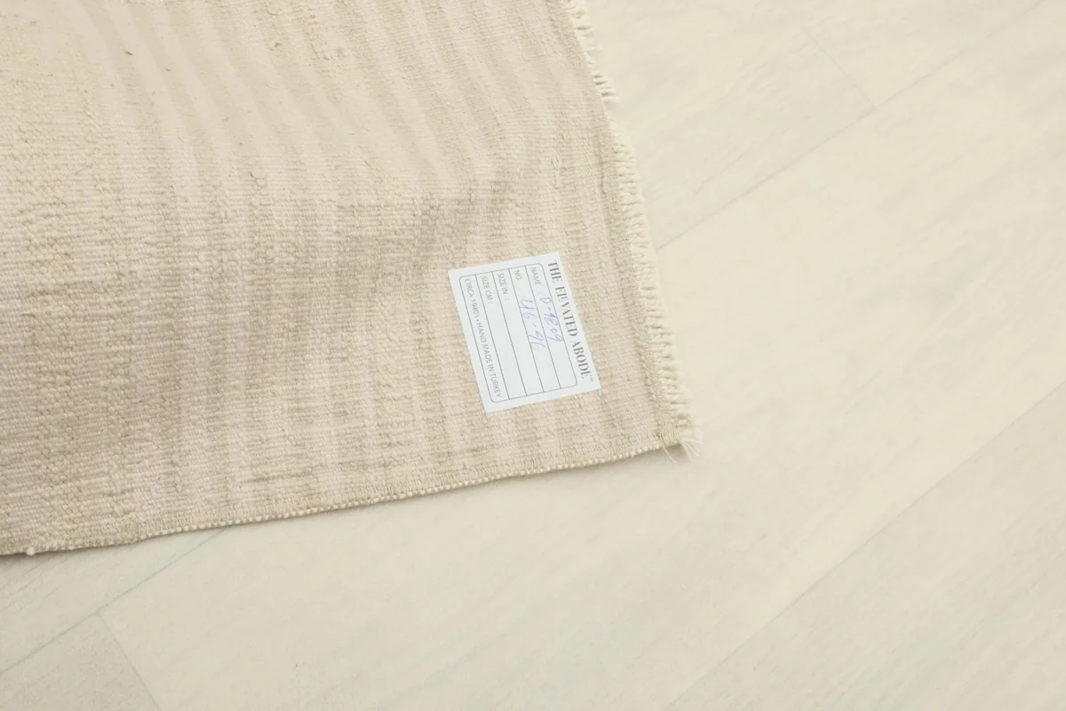 Close-up of the rug's back, showing the woven cotton foundation and the product label.