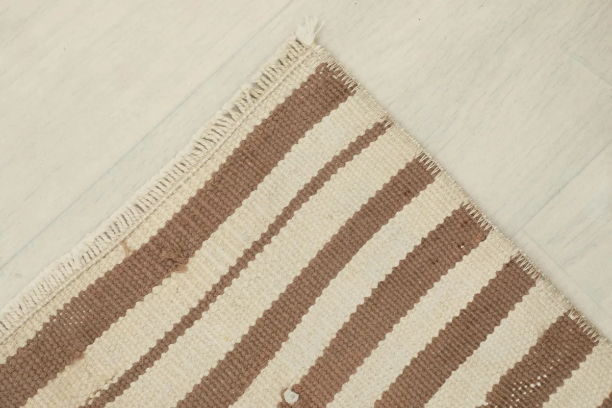 Angled view of the rug's corner, emphasizing its vintage character