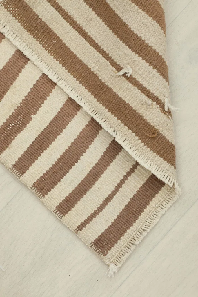 Folded corner of the rug, revealing the thickness and reverse side