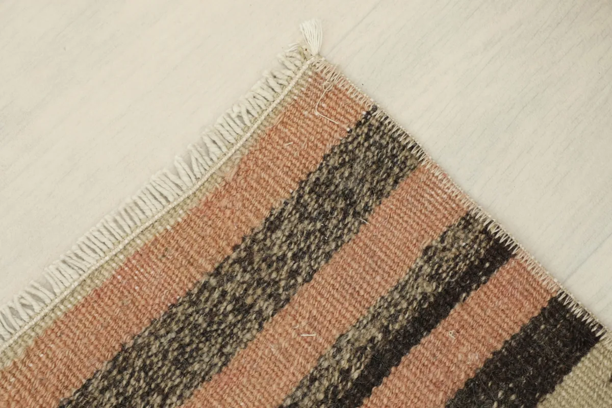 Corner view of the hand-knotted rug, revealing the neat finish of the fringe and the weave.