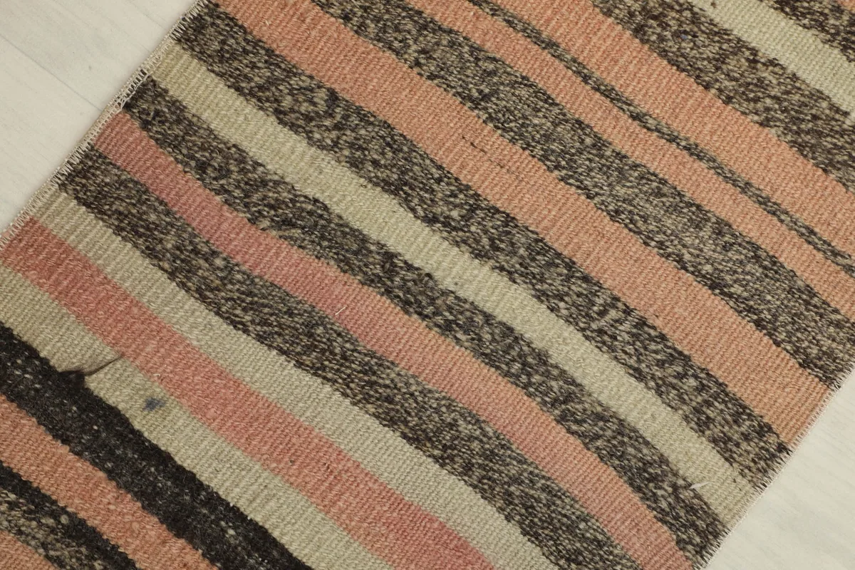 Overhead diagonal view of the vintage doormat, highlighting the varying stripe widths and colors.