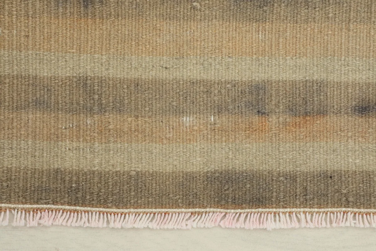 Close-up detail of the muted striped pattern and texture of the vintage wool pile.