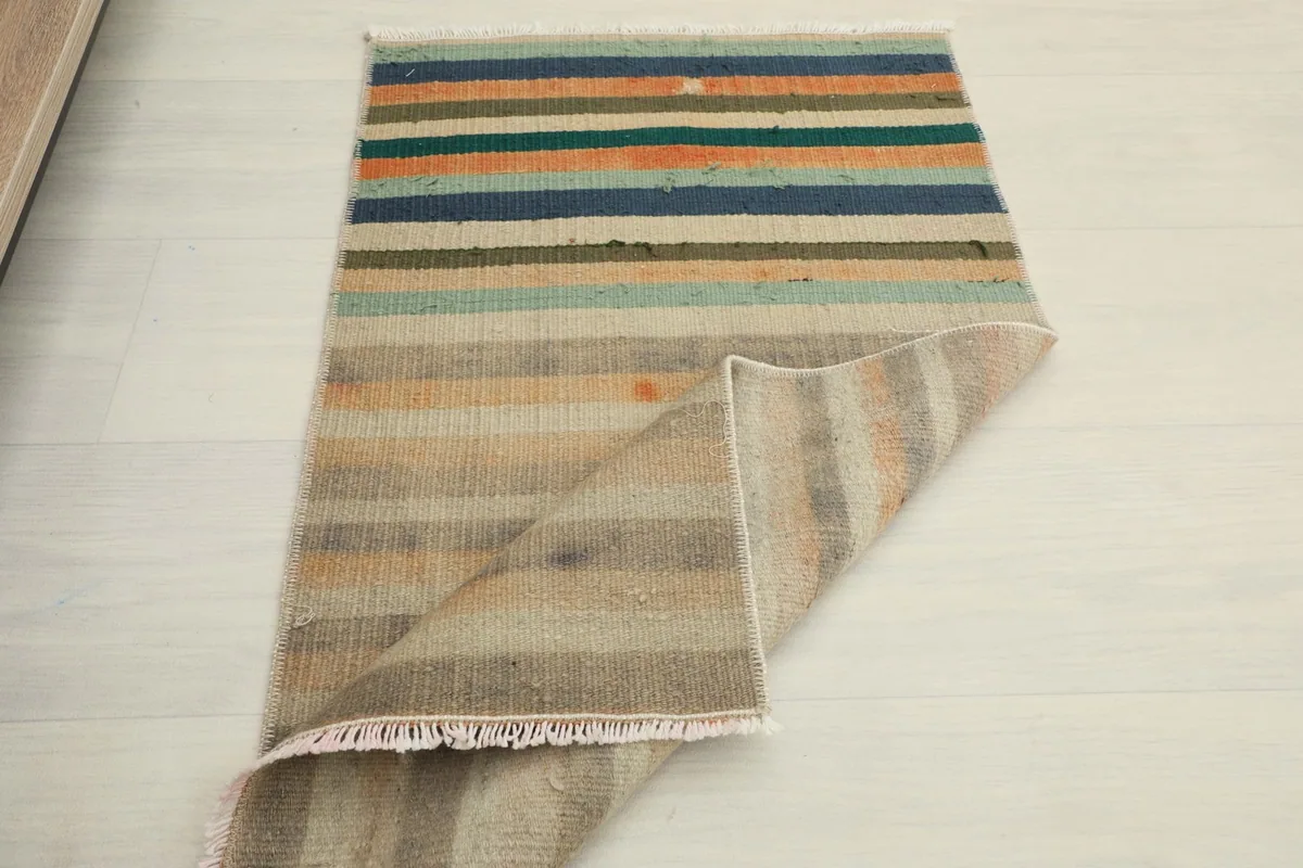 Partial view of the back of the rug, showing the hand-knotted cotton foundation and wool pile.
