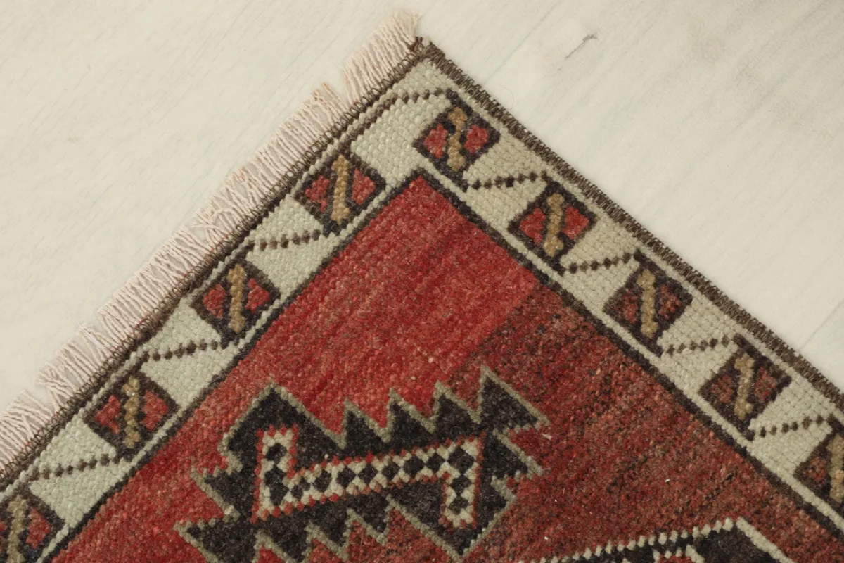 Angled close-up of a corner, highlighting the red field and ivory border