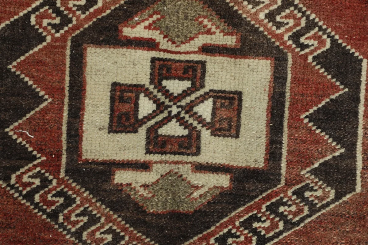 Detailed view of the central ivory and black geometric motif within the rug