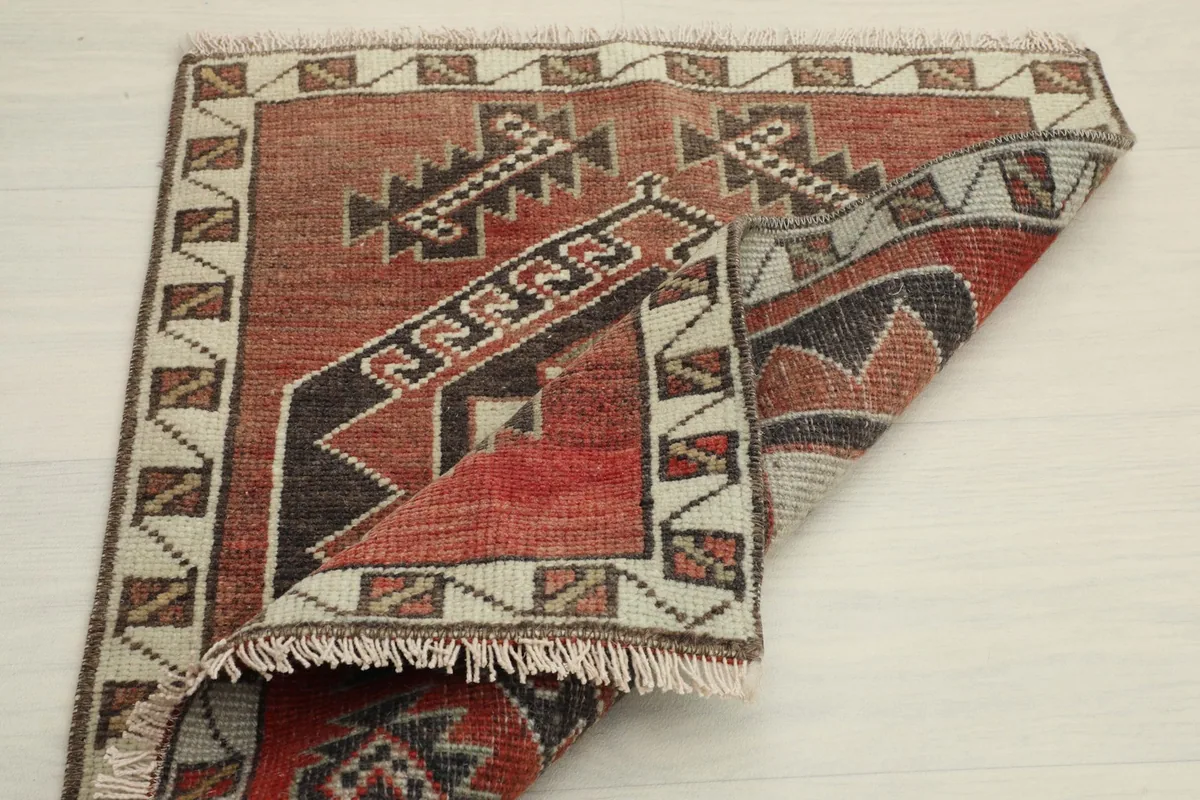 Another view of the rug partially folded, emphasizing its construction and border