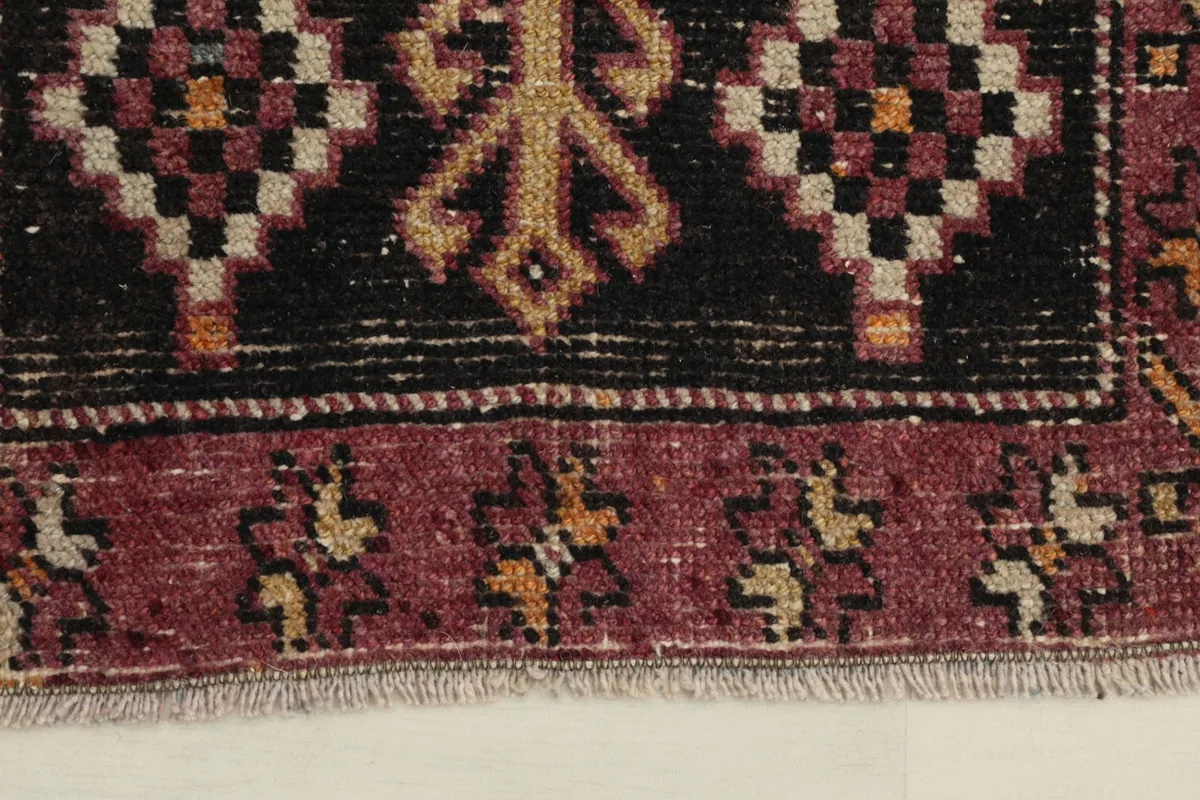 Close-up of the black and rose border with small geometric motifs