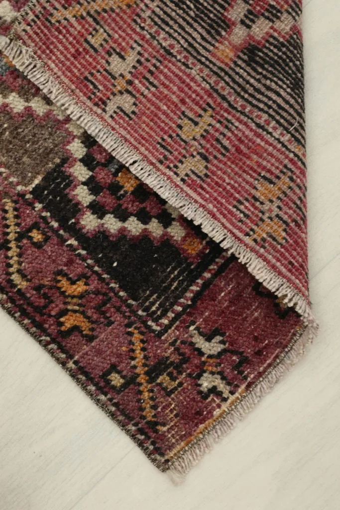 The rug folded to show the back and foundation of the hand-knotted wool