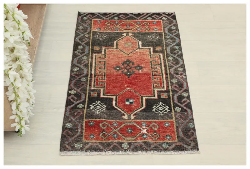 Full top view of the 1'10" x 3'1" vintage Anatolian rug with rust field and charcoal border.