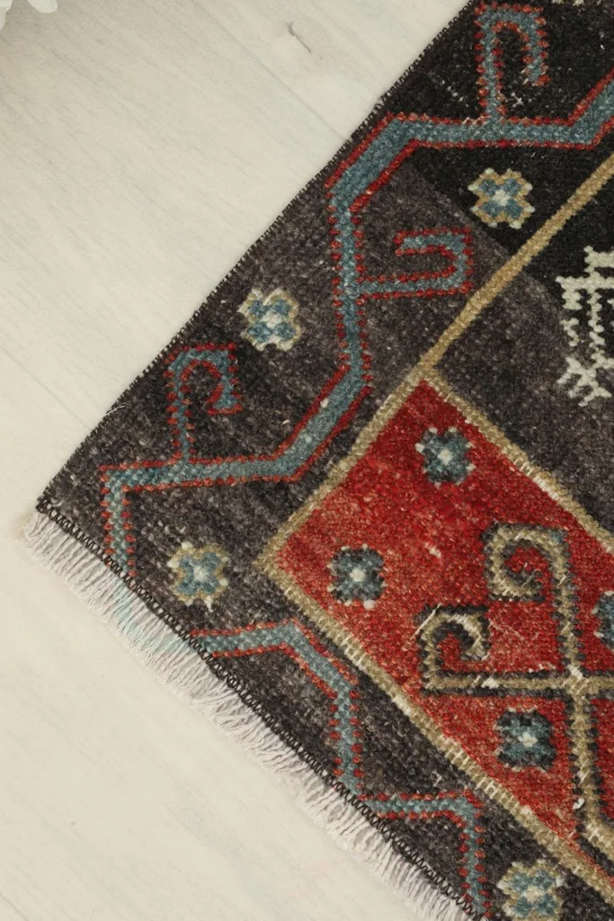 Angled close-up of the rug's corner, emphasizing the wool pile texture and color variations.