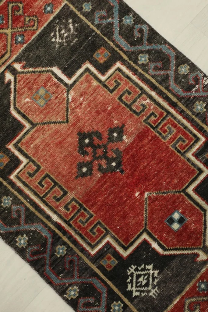 Detailed overhead view of the rug's central rust medallion and surrounding charcoal patterns.