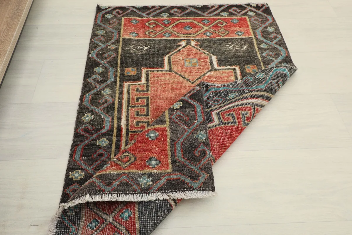Another folded view of the rug, illustrating the overall design and condition from an angle.
