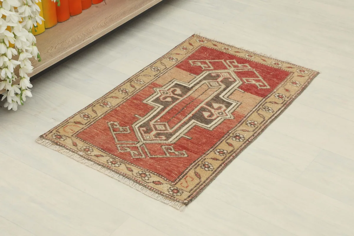 Angled view of the rust vintage doormat on a white floor