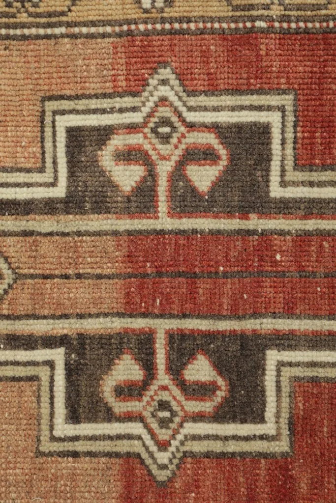Detailed view of the central geometric motif and colors of the rug