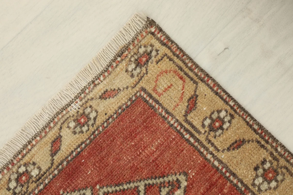 Top corner detail of the rug's tan border and fringe