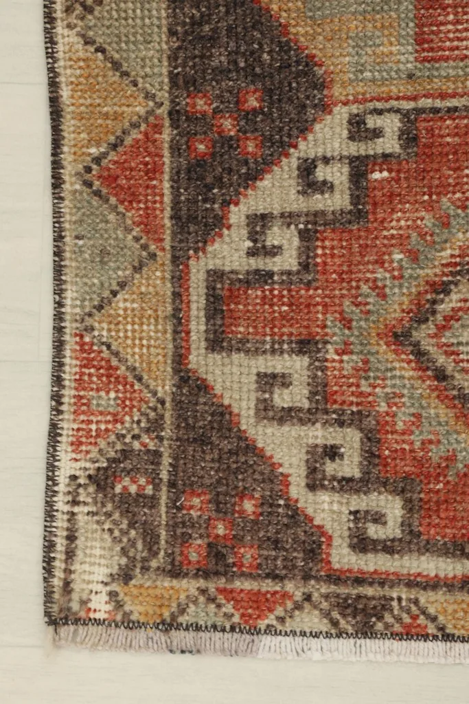 Close-up of the rug's edge, showing the geometric border pattern and the short, natural fringe.