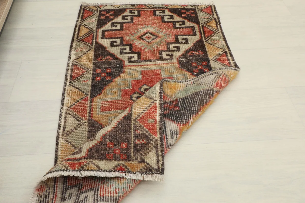 Top view of the rug partially folded, showcasing its flexibility and the full pattern.