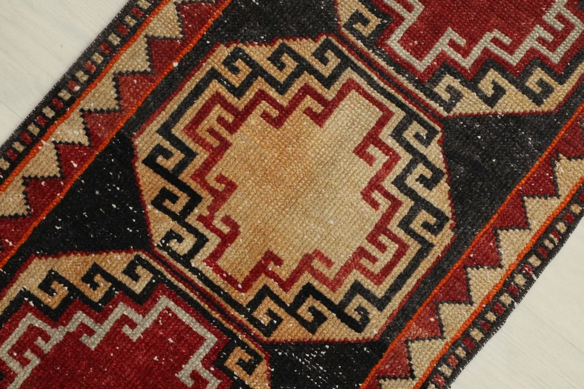 Detailed view of the central tan medallion with intricate black and red lines