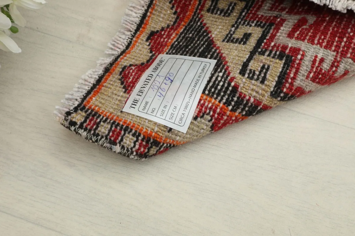 Close-up of the rug's back with a label, showing the cotton foundation and knotting