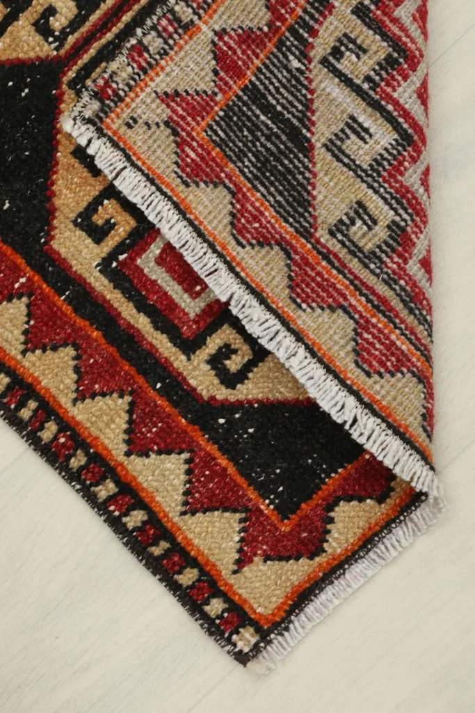 Rug folded to show the back and foundation, revealing the hand-knotted structure