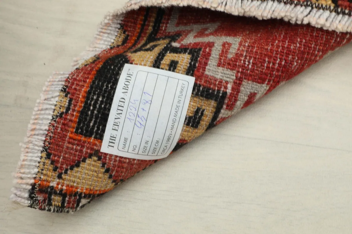 Close-up of the rug's reverse side, displaying the hand-knotted cotton foundation and wool knots.