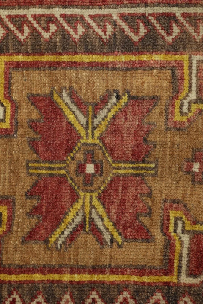 Close-up of the intricate geometric design within the central medallion, showing wool texture.