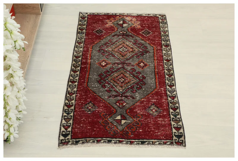 Full top view of the 1'9" x 3'2" vintage Anatolian doormat with a red field and gray central motif.