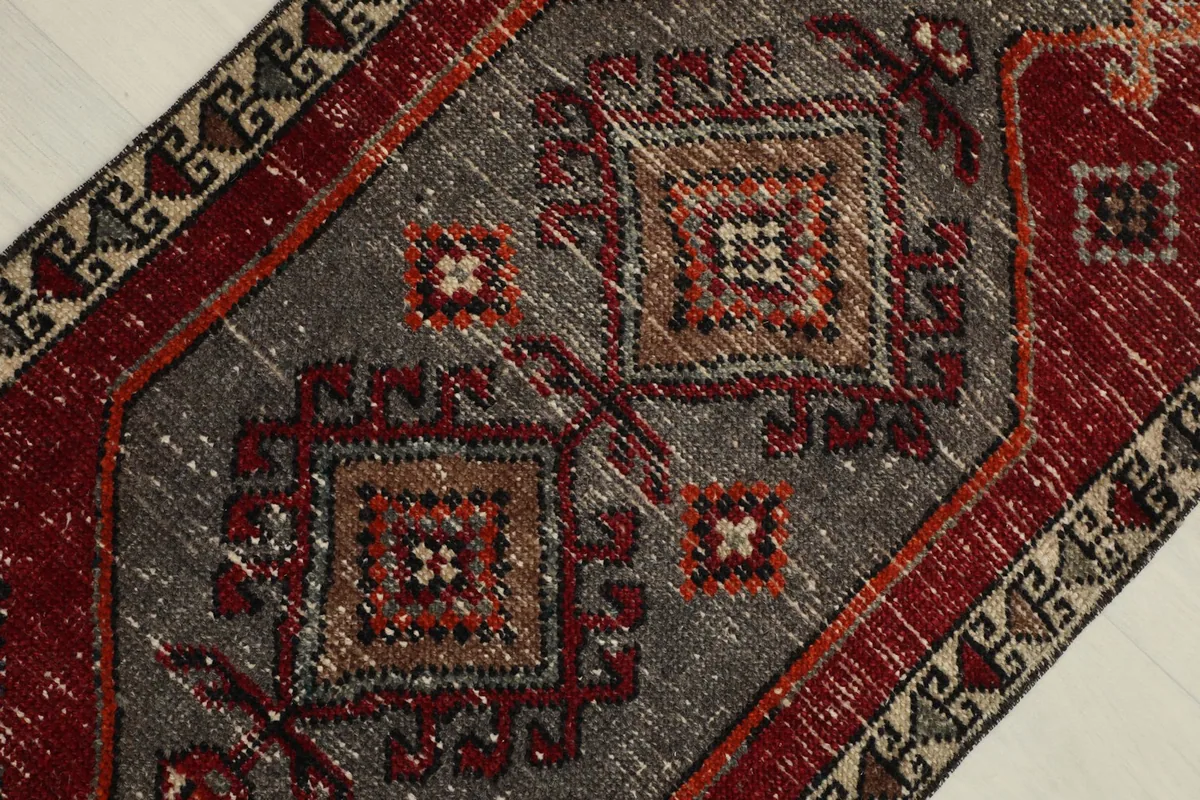 Close-up view of the central gray section of the rug, highlighting geometric patterns and texture.
