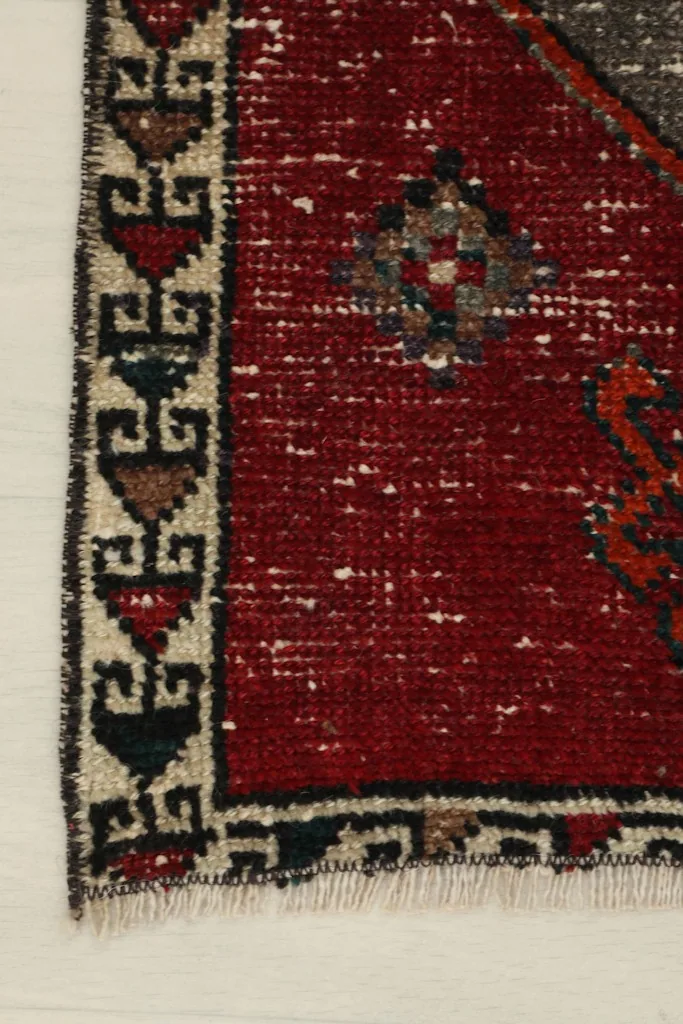 Detail of the side border design with geometric elements in beige, black, and red.