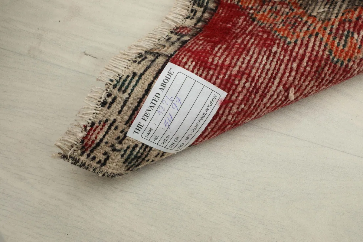 Close-up of the rug's label on the back, showing origin and material details.