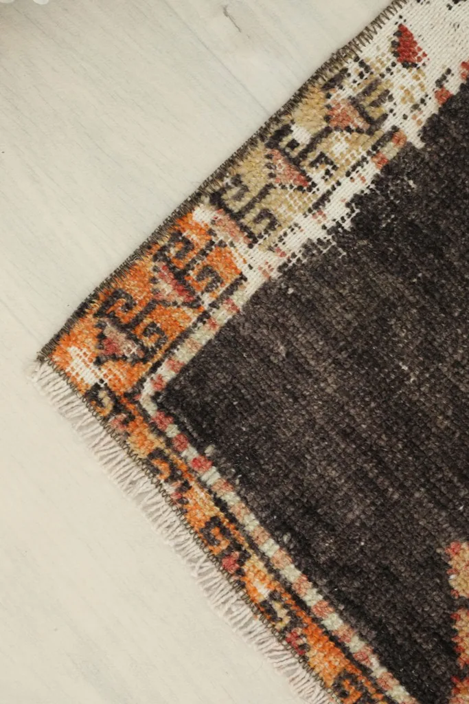 Angled view showing a corner of the rug, revealing the texture and the border design.