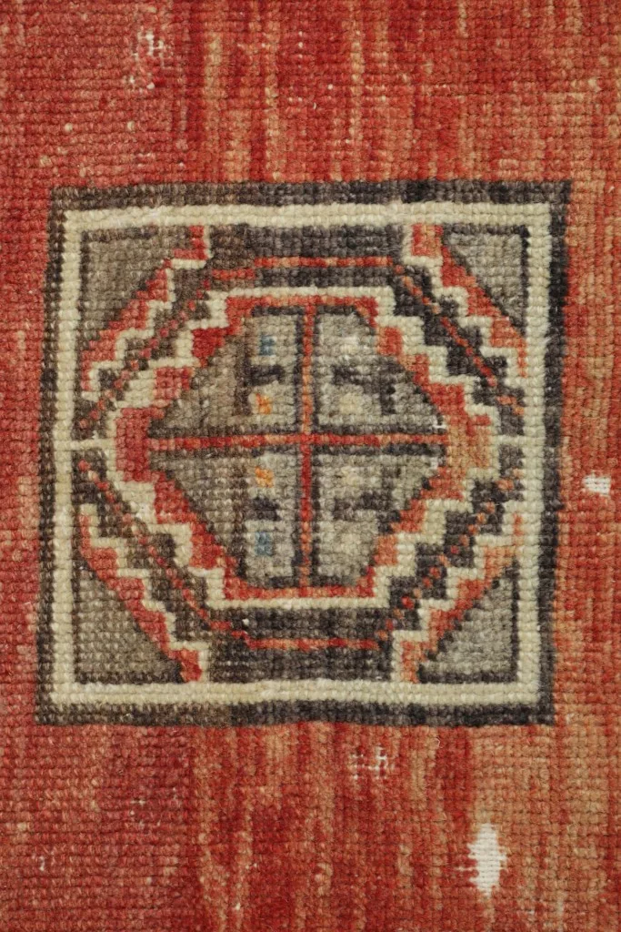 Detailed view of the central square medallion motif, showing intricate patterns and color variations.