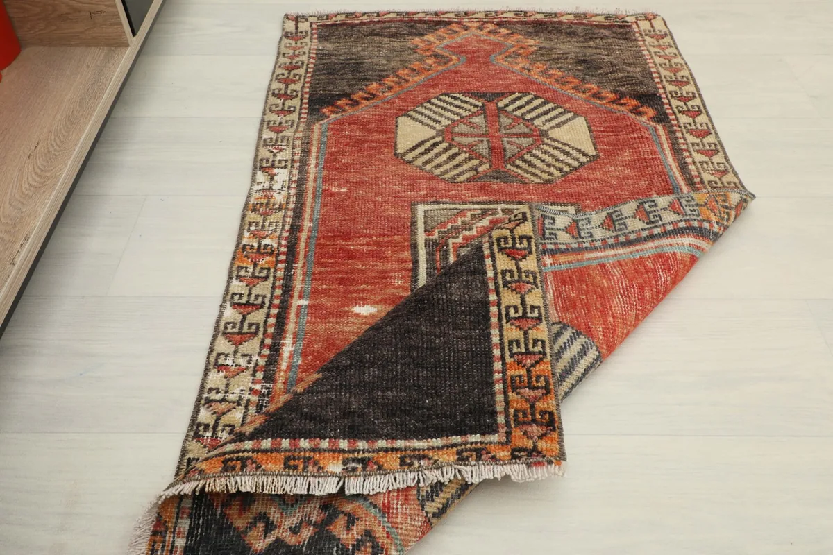 The rug partially folded to show its flexibility and the different patterns across its length.