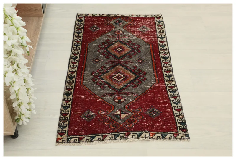 Full top view of the 1'10" x 3'3" red and gray vintage Anatolian area rug on a white background.