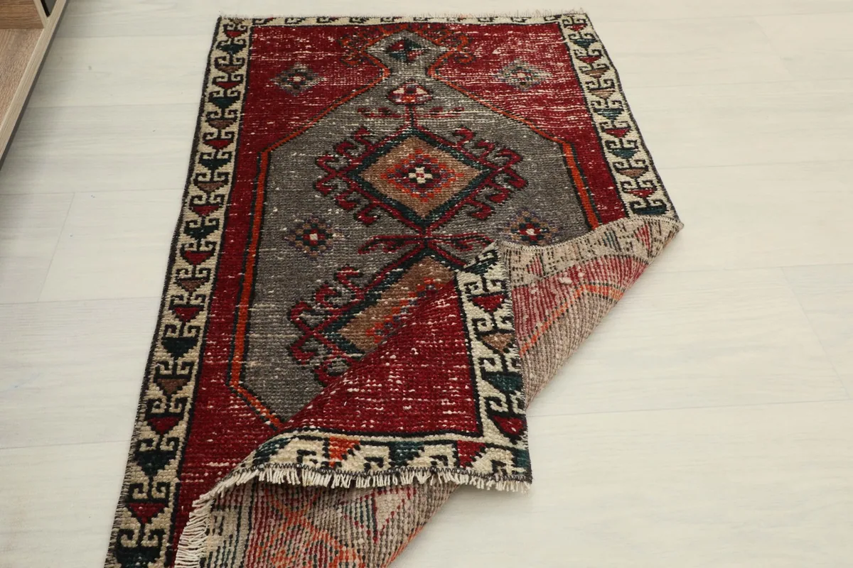 Another view of the rug with a corner folded back, showing the full design and the rug's flexibility.