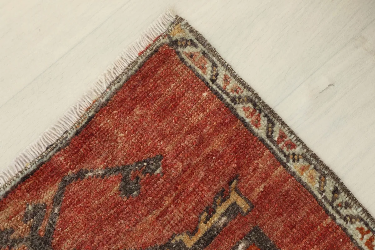 Angled view of a rug corner, revealing the hand-knotted construction and the fringe.