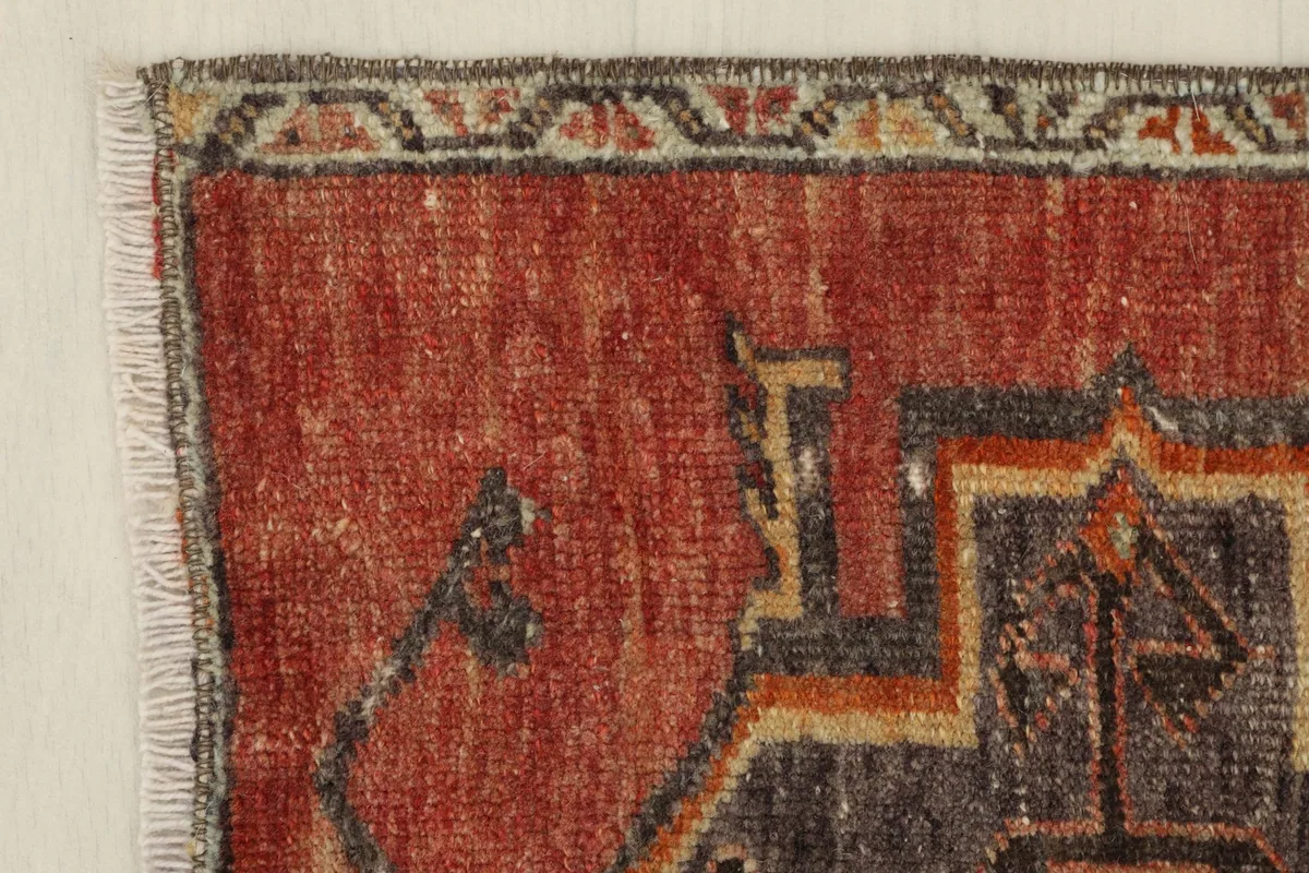 Corner detail of the rug showing the subtle border design and the texture of the low wool pile.