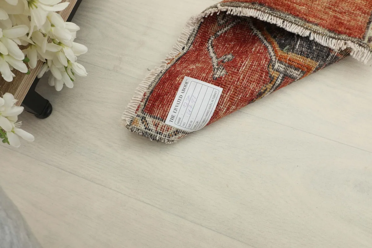 Back of the rug with a label, showcasing the cotton foundation and hand-knotted construction.