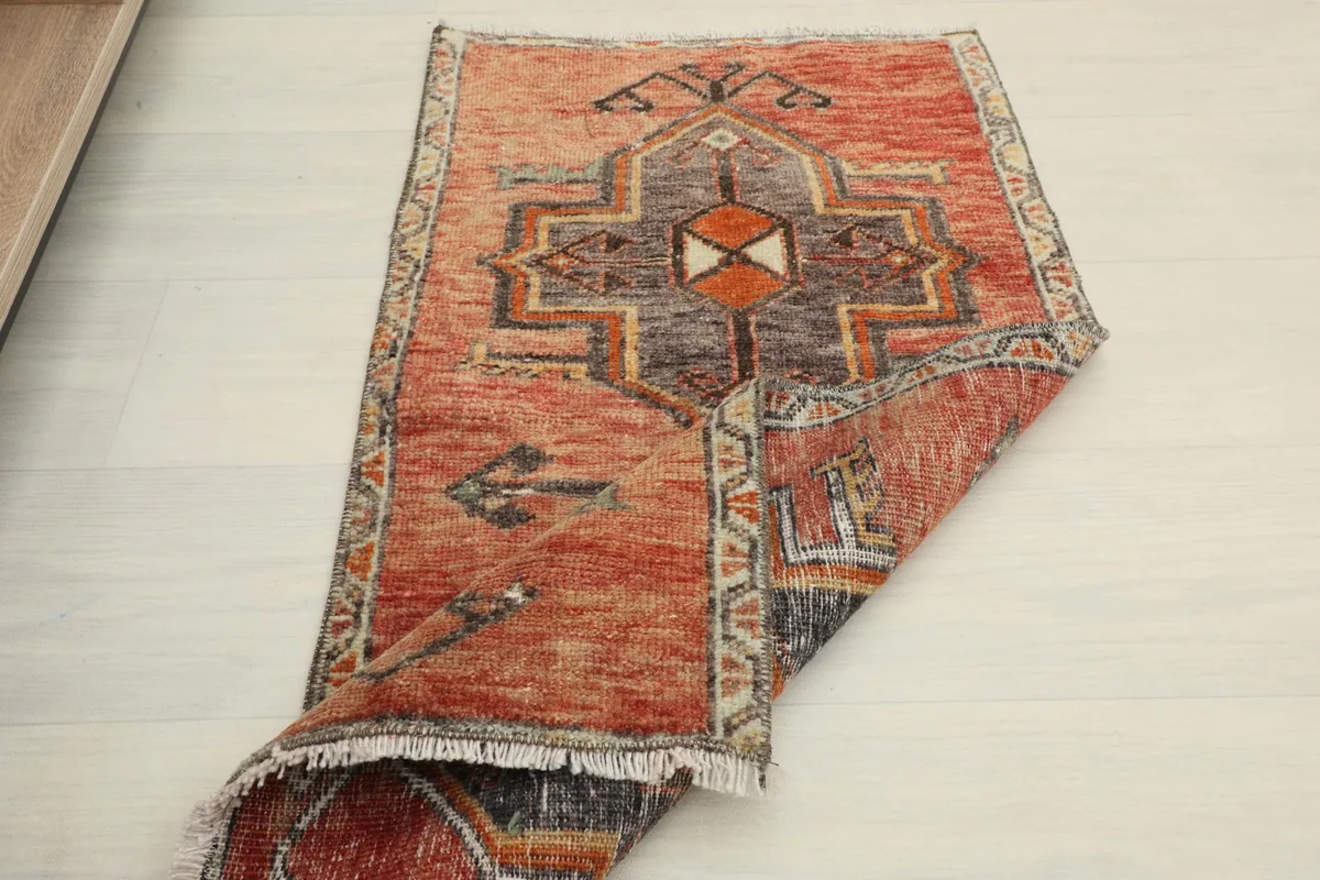 Another view of the rug partially folded, showing the full design and the reverse side.