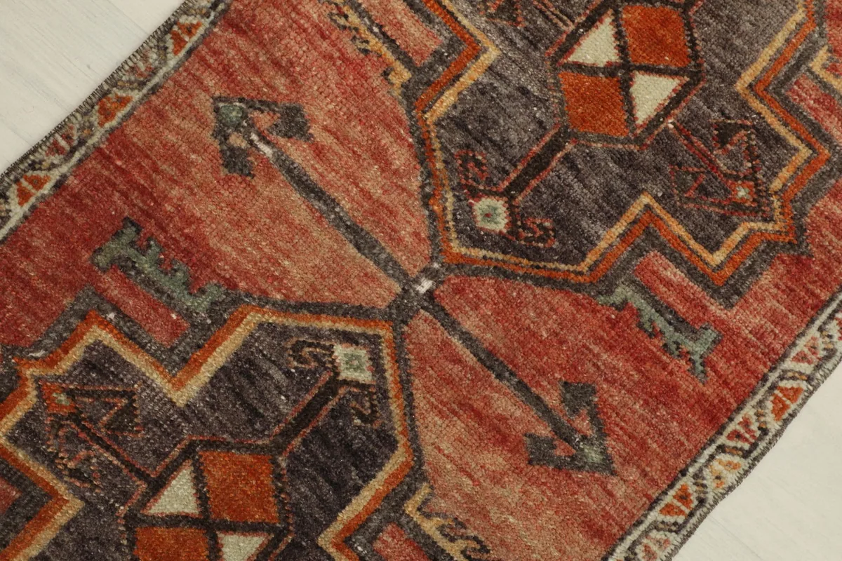 Overhead detail showing the intricate geometric design and color variations across the rug's surface.
